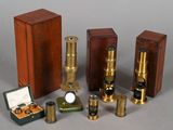 plusieurs types de microscopes et de boîtes posés sur une surface grise