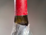 a bottle of wine wrapped in plastic on a table