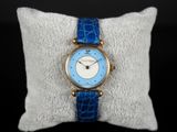 un gros plan d'une montre-bracelet posée sur un oreiller