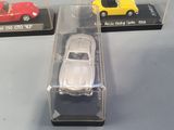 three toy cars in a display case on a table