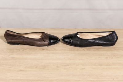 a pair of black and brown shoes sitting on top of a wooden table