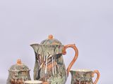 a tea set that includes a teapot, cup, saucer, and saucer