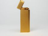 a gold lighter sitting on top of a white surface