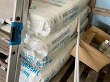 un homme qui se tient à côté d'une pile de sacs