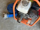 un petit moteur posé par terre à côté d'un tuyau