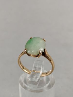 an image of a gold ring with a green stone on it