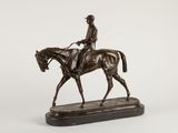 bronze statue of a jockey on a horse on a marble base