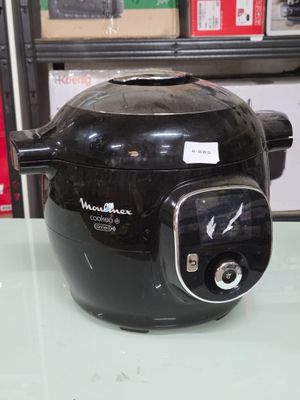 une photo d'une friteuse électrique noire posée sur une table en verre