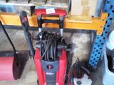 a picture of a red and black electric pressurer in a garage