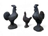trois figurines de coqs sur fond blanc