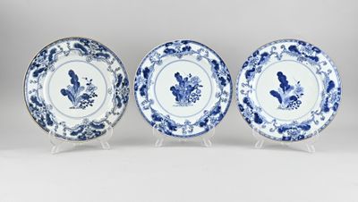 three blue and white plates with floral designs on them