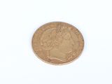 a close up of a gold coin on a white surface