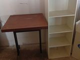 une petite table et une bibliothèque dans une pièce
