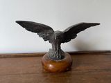 une statue représentant un aigle perché sur une table en bois