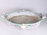 an old metal tray with a handle and a flower design on it