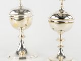 a pair of silver goblets with a cross on the top