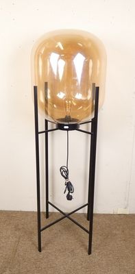une lampe posée sur un pied et munie d'un cordon d'alimentation