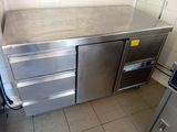 a stainless steel counter in a kitchen with a refrigerator