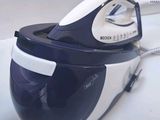 a black and white steam iron sitting on a white surface