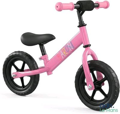 le petit vélo rose est posé sur une surface blanche