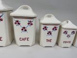 three white ceramic containers with red and blue designs on them