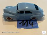 une petite voiture bleue posée sur une feuille de papier