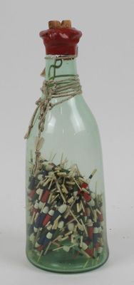 a glass bottle filled with a lot of small objects