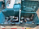 deux caisses bleues posées par terre, contenant des outils