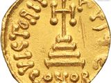 a close up of a gold coin with a cross on it