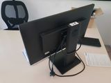 a computer monitor sitting on a desk with a keyboard and mouse