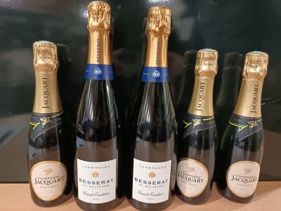 cinq bouteilles de champagne sont alignées sur une table