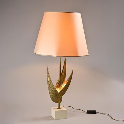 gold leaf table lamp with a white shade on a marble base