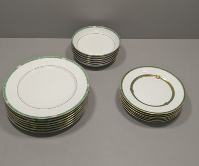 quatre assiettes à bord doré et bordure verte sur fond gris