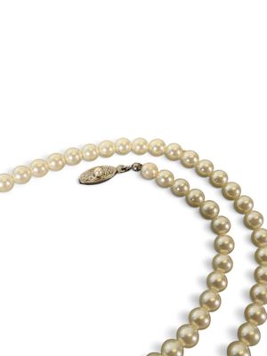 gros plan d'un collier de perles sur fond blanc