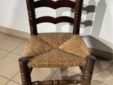 a wooden chair with a woven seat on a tiled floor