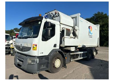a white garbage truck parked in a parking lot