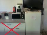 une photo d'une cuisine équipée d'un micro-ondes, d'un réfrigérateur et d'une télévision