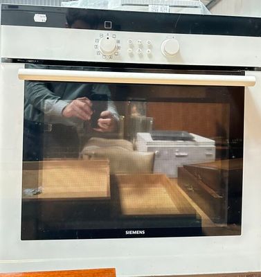 a person taking a picture of an oven in the kitchen
