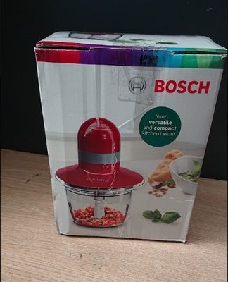 boxed box of a red food processor sitting on a wooden table