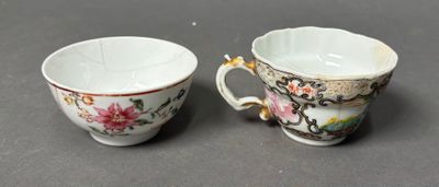 pair of porcelain cups with floral designs on them sitting on a table