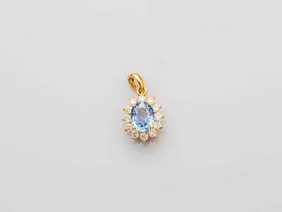 a blue topaz stone and diamond pendant on a white background
