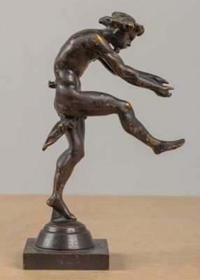 statue en bronze représentant un danseur, posée sur un socle posé à son tour sur une table en bois