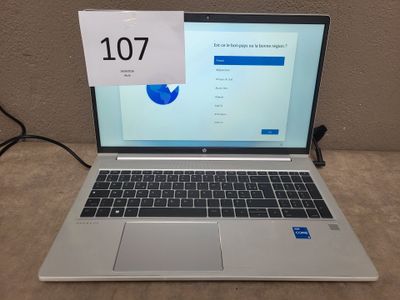 a laptop that is sitting on a table with a sign on it