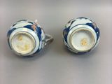 pair of blue and white vases on a table with a white background