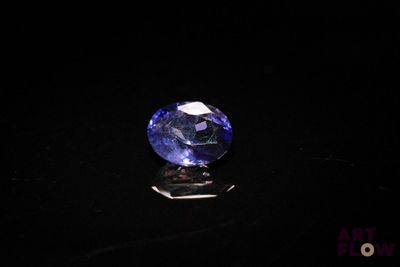 a blue sapphire stone sitting on top of a black surface
