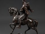 a bronze statue of a man riding a horse on a marble base