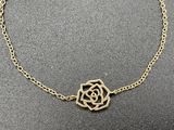 a gold necklace with a rose on a chain
