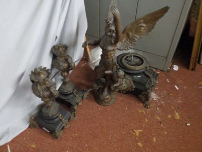 two statues of angels and a clock on the floor