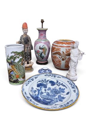 several vases, plates, and figurines are displayed on a white surface