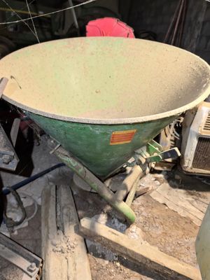 a green wheelbarrow sitting on top of a pile of wood